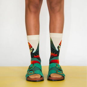 Person with green sandals wearing Bonne Maison Toucan socks on white backdrop.