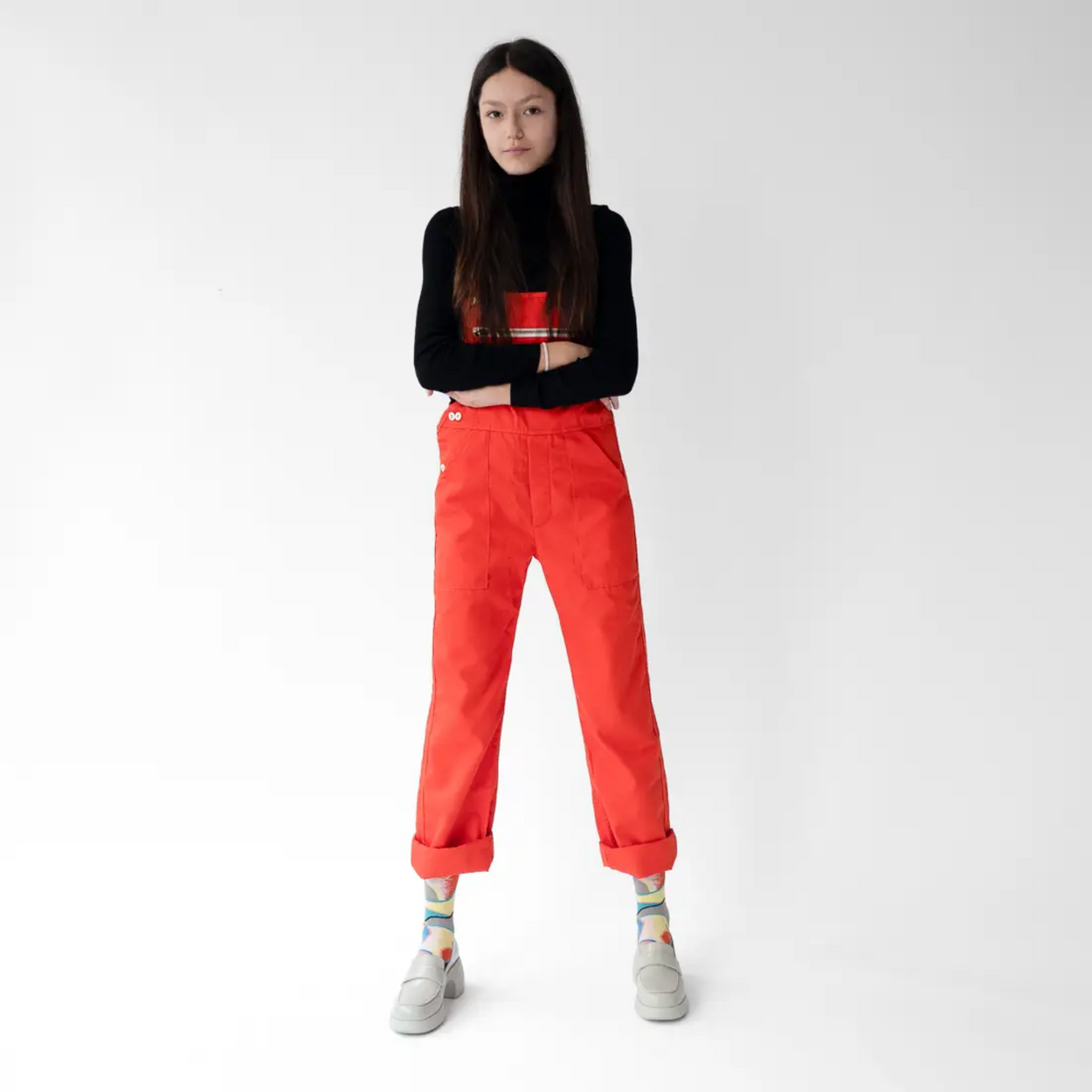 woman in red jeans wearing Bonne Maison Patchwork socks against a white backdrop.