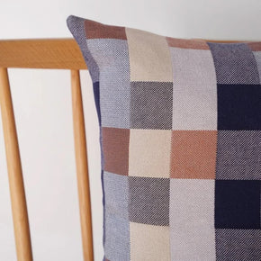 Close up of Mungo Seven Seas Checkered double cotton pillow on a wooden chair against a white background