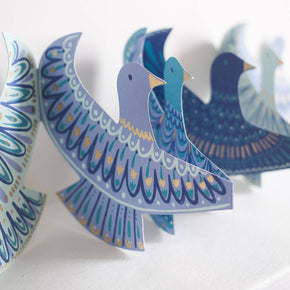 Decorative paper birds with blue and white patterns on a white background