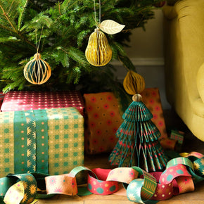 Decorated Christmas tree with ornaments and presents in a room.