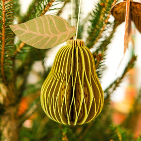 Decorative yellow ornament hanging on a Christmas tree branch