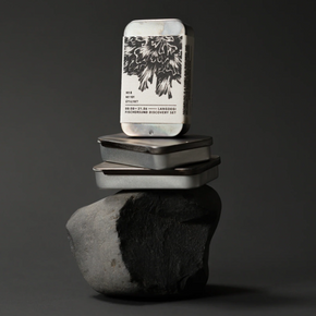 Stack of small metal Discovery Sets on a reflective surface with a dark background