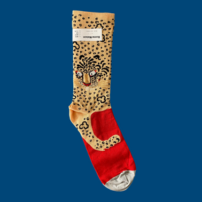 Bonne Maison Leopard Socks lying flat with blue backdrop