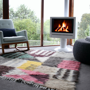 Bauhaus hand woven pure wool area rug in sitting room with rocking chair and white fireplace