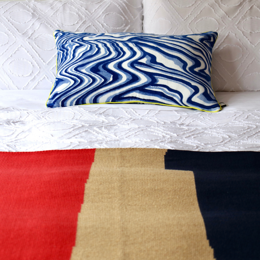 Marbled French Velvet Cushion Cover in blue on white bed with blue and red blanket