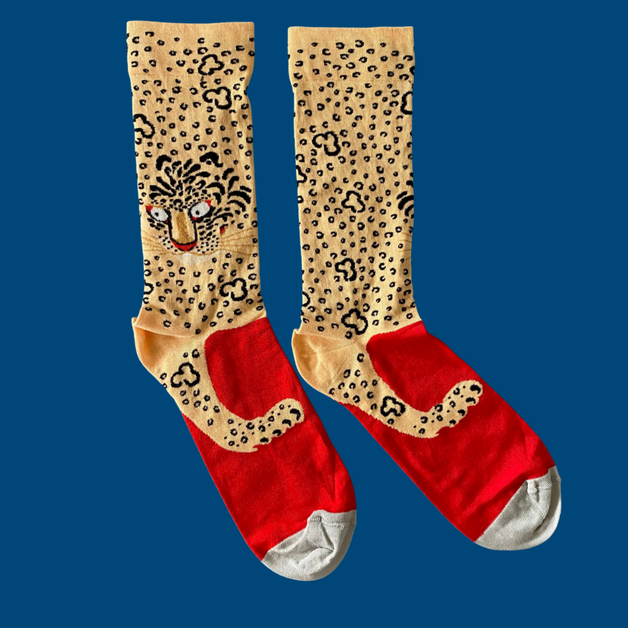 Bonne Maison Leopard Socks lying flat with blue backdrop