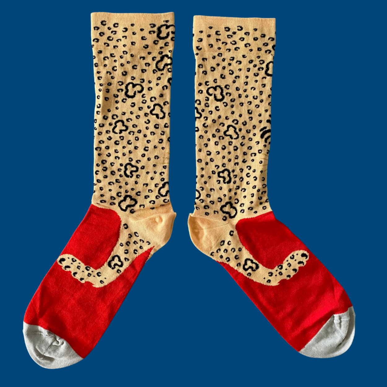 Bonne Maison Leopard Socks lying flat with blue backdrop