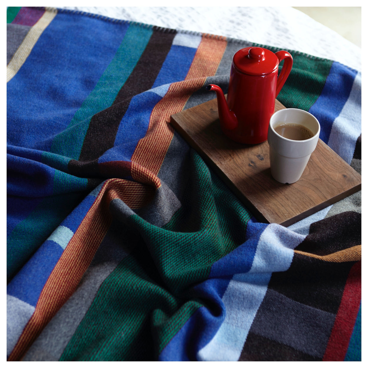 Blue Premium Merino Lambswool wool throw blanket on bed with tea set