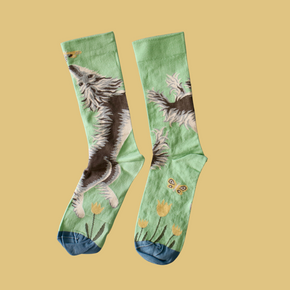 Bonne Maison Dog Socks seen front and back, lying flat against a yellow backdrop