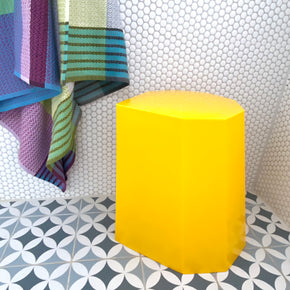 Arnold Circus Stool in yellow in tiled pale grey shower recess with bright towels.