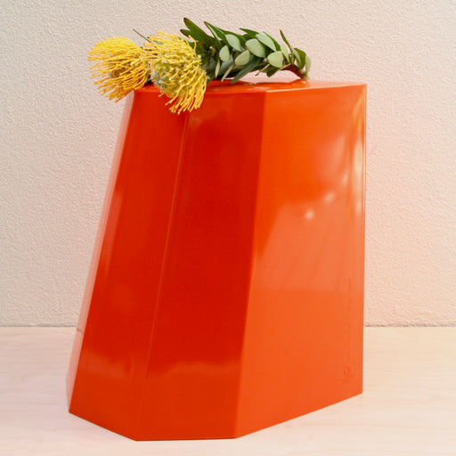Arnold Circus Stool in Tangerine Orange - with yellow flowers on top.