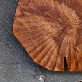 Hand carved Lotus leaf walnut wood plate, close up against slate