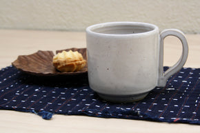 Ceramic cup and wood plate with biscuit sitting on a Vintage Japanese Indigo PlacematVintage Japanese Indigo Placemat