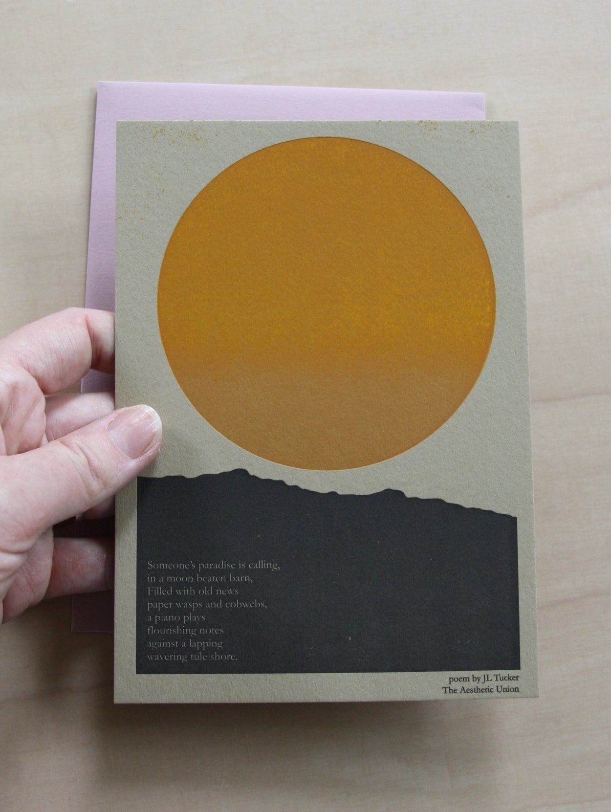 Hand holding Hand printed greeting card with yellow sun and poetry note