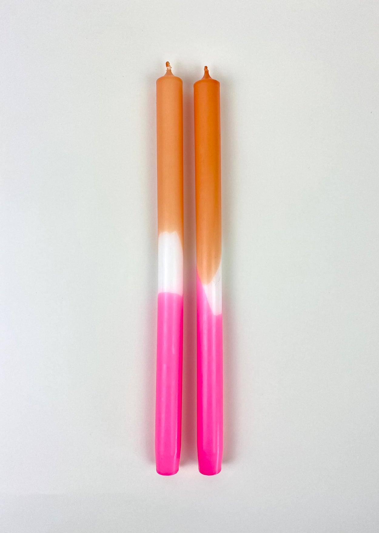 Hand Dipped Dinner Candles - Pink and orange with white background.