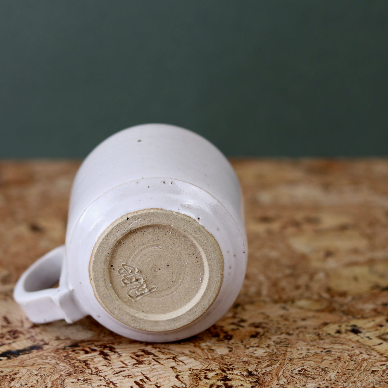 Handmade Ceramic Coffee Mug - Large by Richard Beauchamp, base view, on cork background.