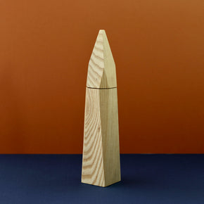 Ash wood salt grinder by Martino Gamper with blue and brown background