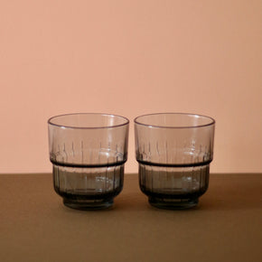 Smokey Grey Portuguese glasses x 2 with brown and peach background.