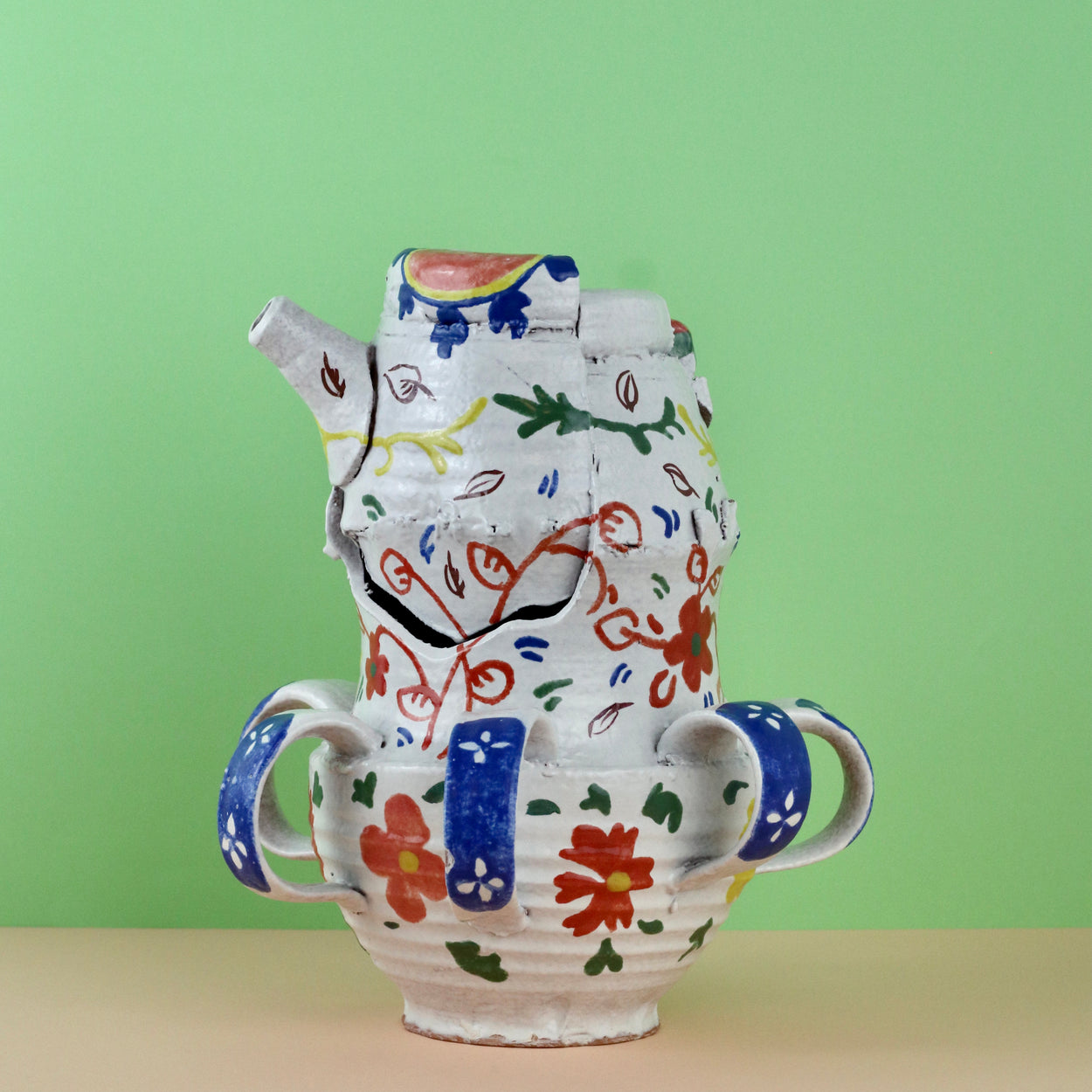 Handmade Ceramic Pentref Jug by Elin Hughes against a green and peach background.