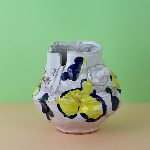 Modern Ceramic Vase by Elin Hughes against a light green and peach background.