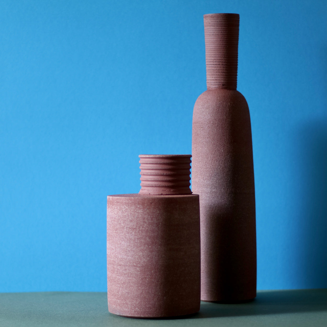 Group view of Handmade Ceramic Vases by Amanda-Sue Rope against a blue and green background.