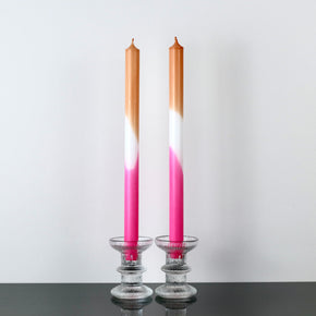 Hand Dipped Dinner Candles - Pink and Orange in glass candle sticks with white background.