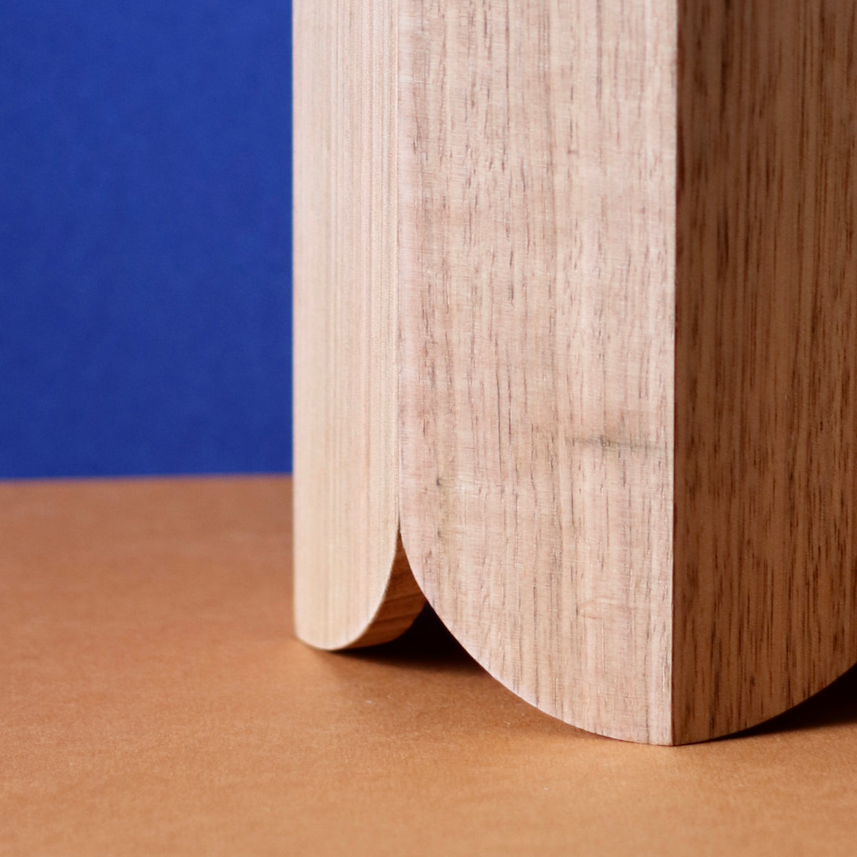 Close Up of Handmade Wood Kitchen Utensil Holder in oak against a blue and brown background.