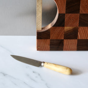 Pallares Solsona 10cm Box Wood Stainless Steel Kitchen knife on marble bench with wood chopping board behind