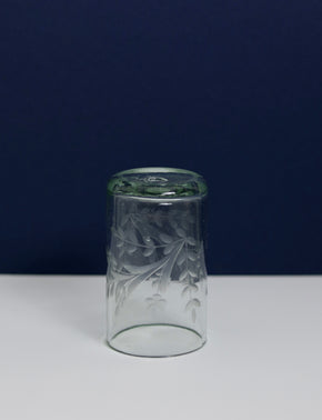 Upside down Hand blown etched glass tumbler with blue and white background.