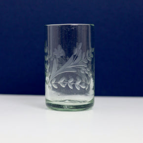 Hand blown etched glass tumbler with blue and white background.
