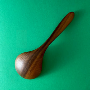 Back view of Handmade Walnut Wood Soup Ladle with green  background by Civil Dawn Studio