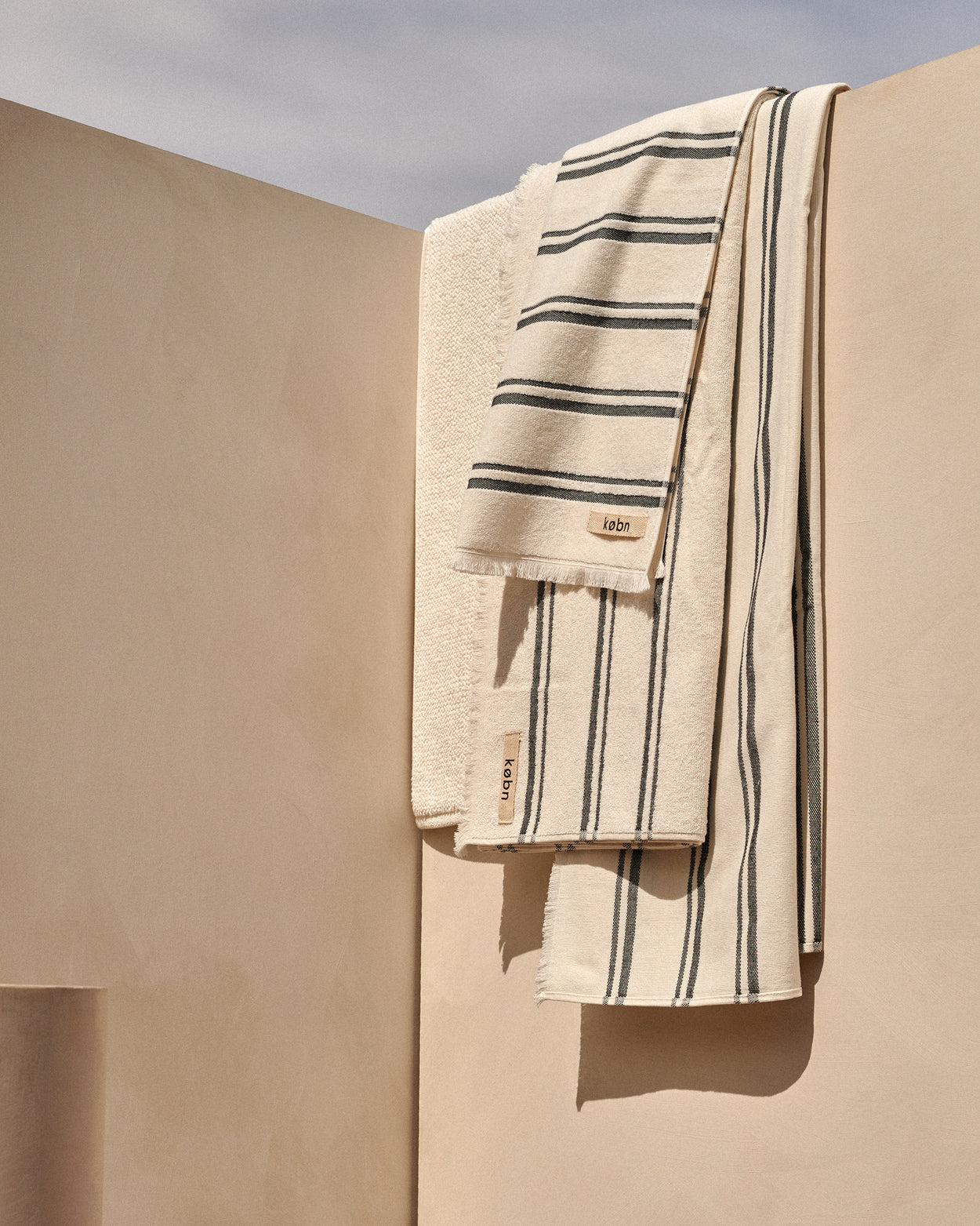 Købn Crema towel series hung over beige wall