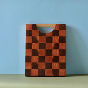 Handmade checkered Oak and Walnut cutting board standing upright