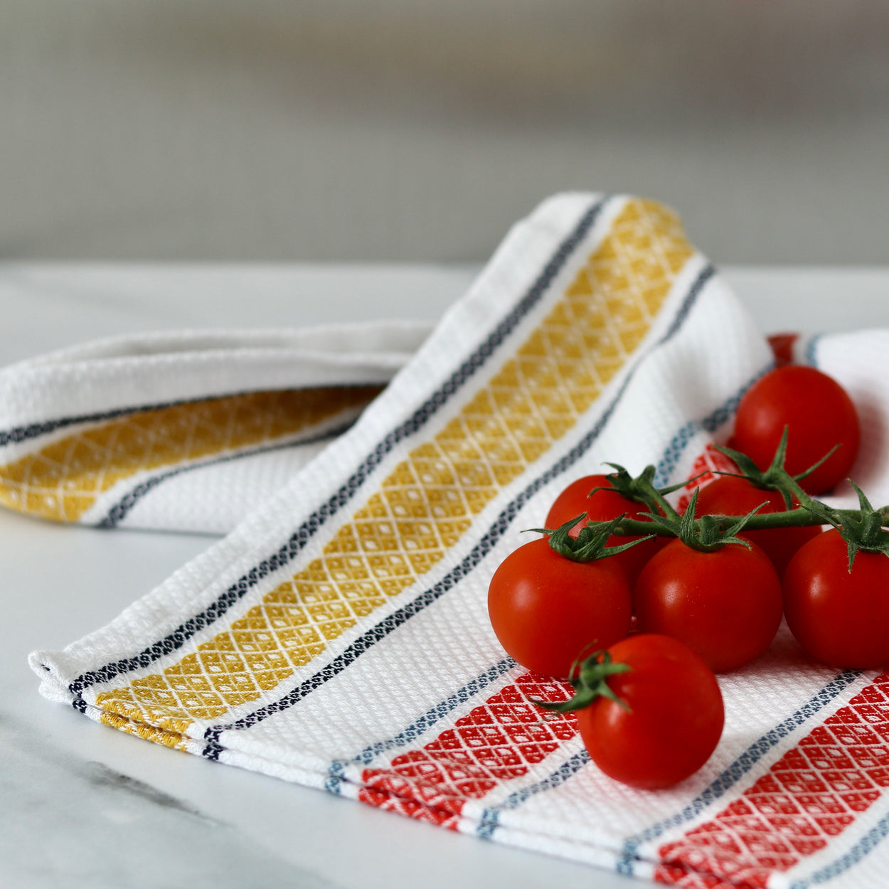 Close up Pure cotton Portuguese tea towel with cherry tomatoes.