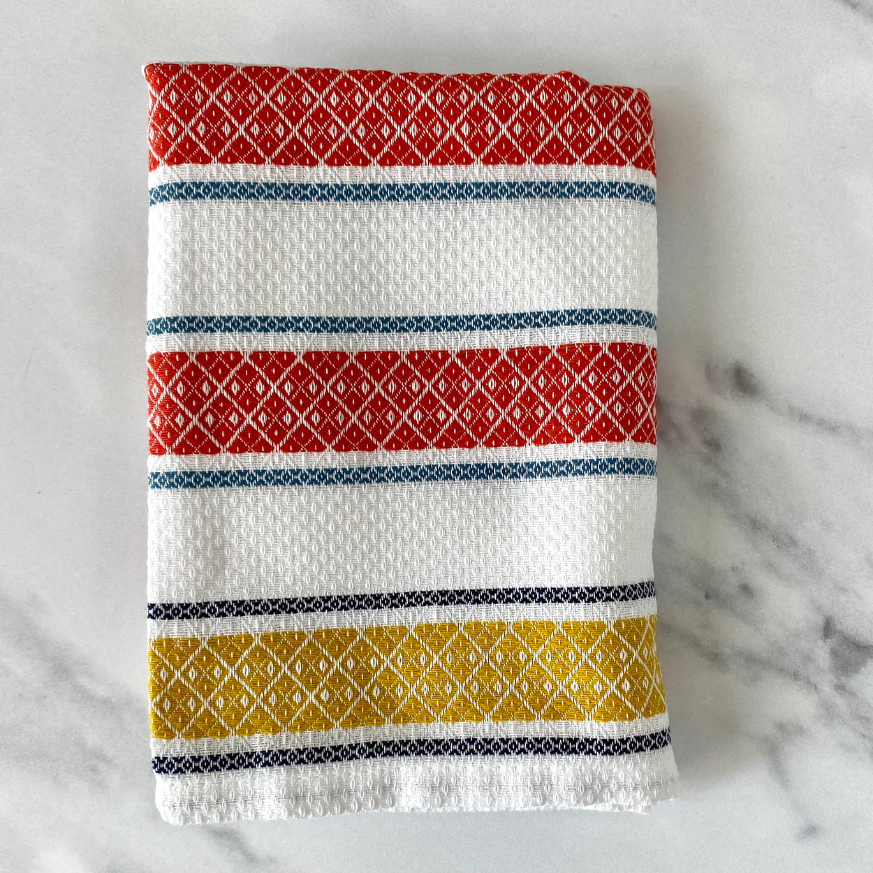 Folded Pure cotton Portuguese tea towel on marble bench