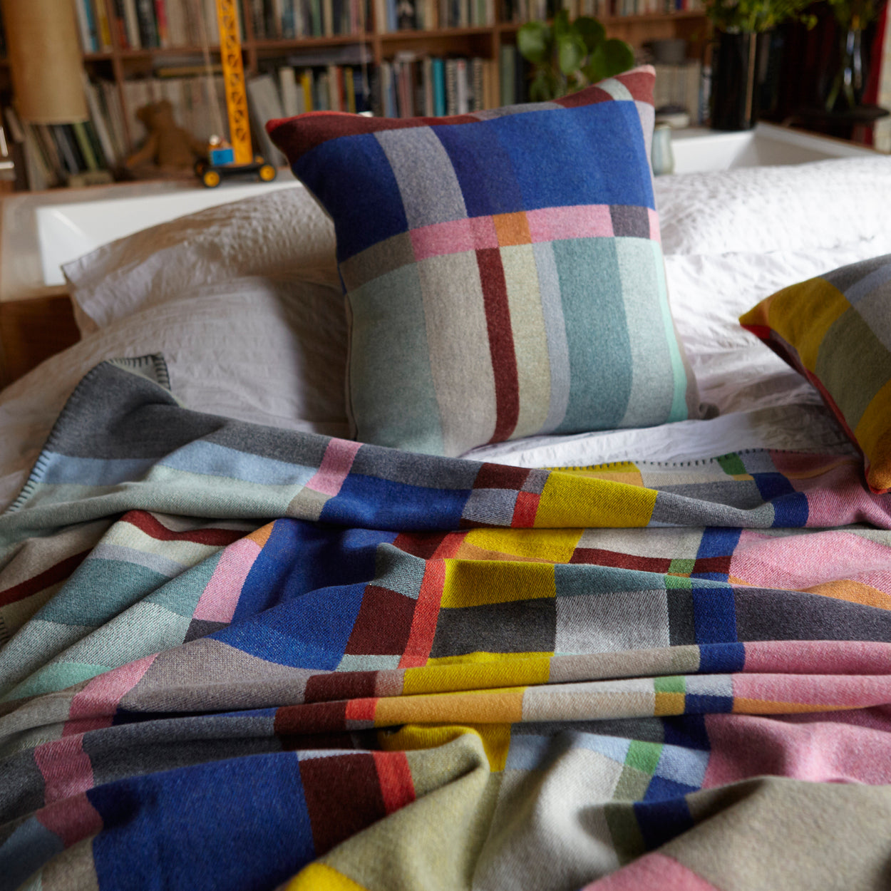 Premium Merino wool cushion cover in Lloyd with blankets on strewn top of bed