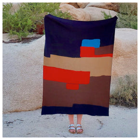 Woman holding modern blue, red, tan and brown cotton knit throw blanket from Civil Dawn Studio