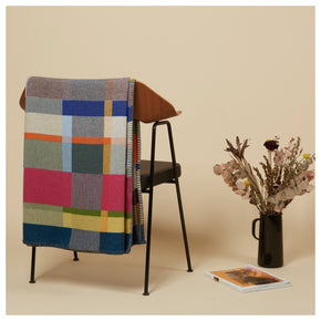 Premium Australian Merino Wool Throw Blanket in bright pink and blue on chair with magazine and flowers