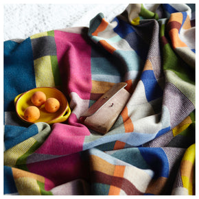 Premium Australian Merino Wool Throw Blanket in bright pink and blue, with fruit on bed