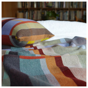 Cecil Orange and brown Premium Merino Lambswool wool throw blanket on bed with cushion