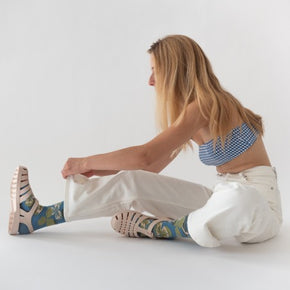 Woman in white jeans and crop top sitting on the floor wearing Bonne Maison Clover Socks