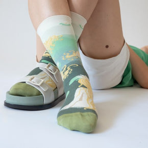 Woman lying down with white shorts and Bonne Maison Swimmer Socks in white sandals