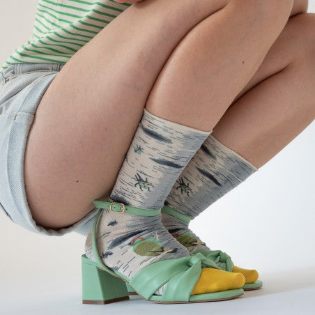 Girl in denim shorts wearing Bonne Maison Insect Socks with pale green heels.