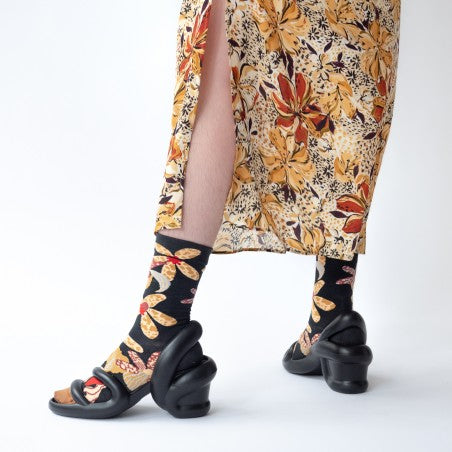 Woman in floral skirt and black heels wearing Bonne Maison Orchid Socks